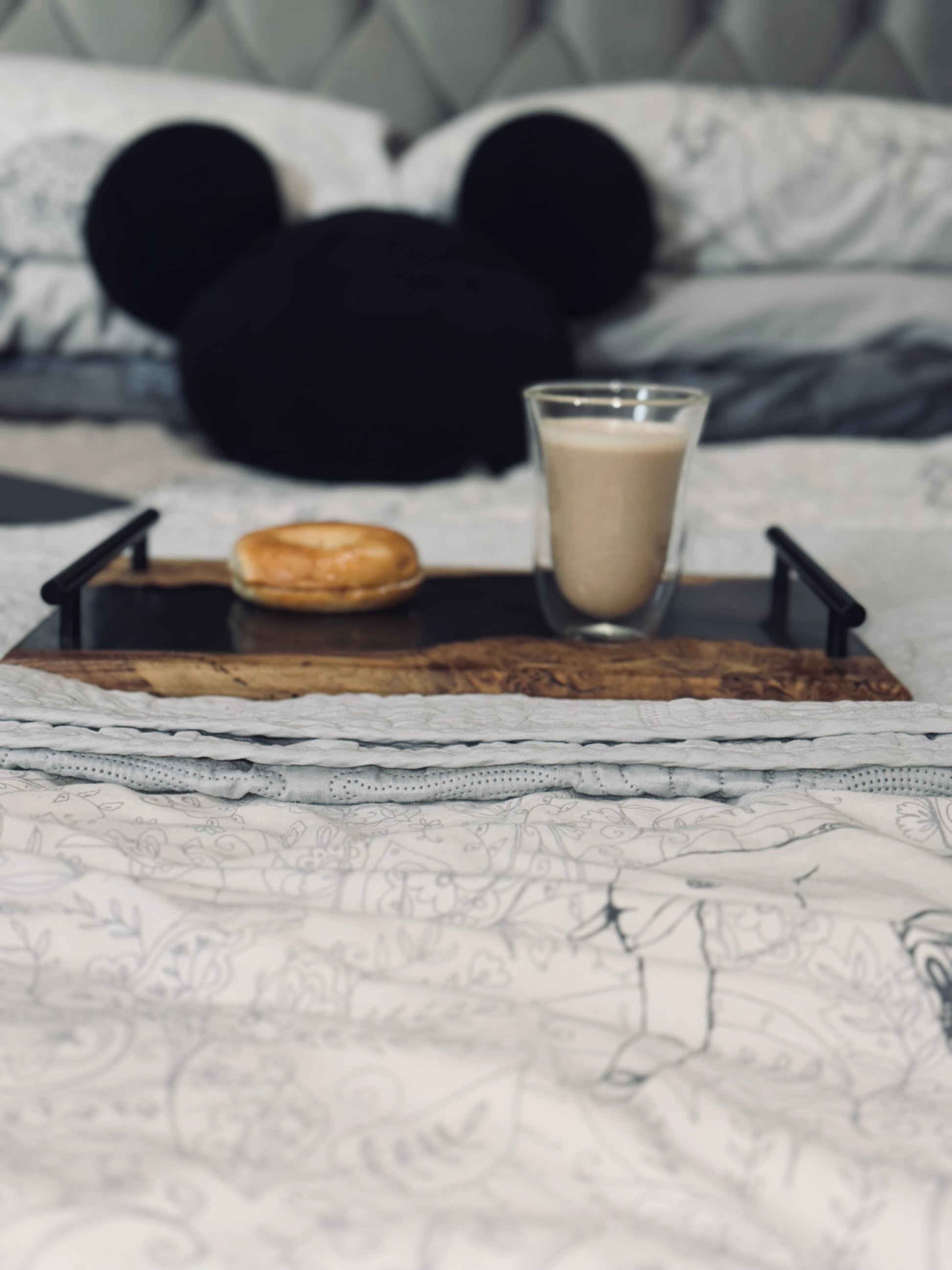 Oak and Smokey Epoxy Serving Tray on a bed with a glass of coffee and a bagel. Serving suggestion.