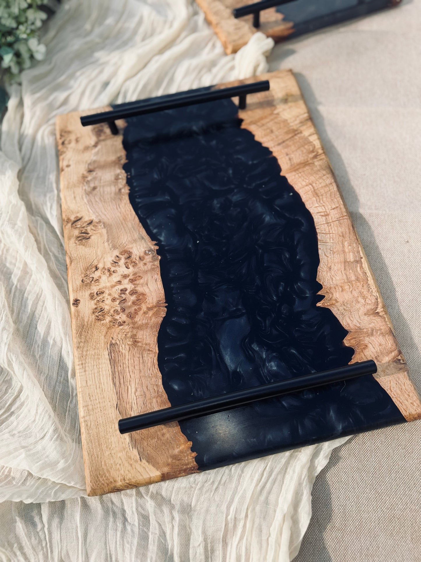 Oak burr and black onyx epoxy serving tray image of tray in full view on a graden table