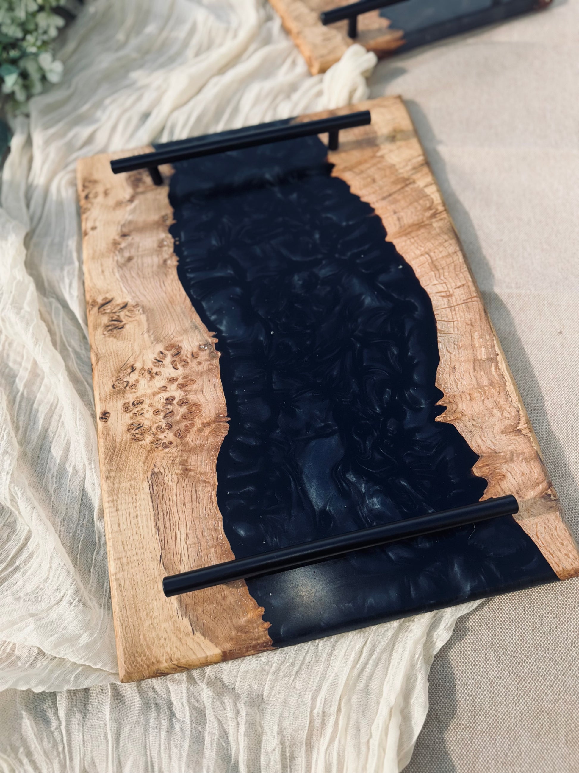 Oak burr and black onyx epoxy serving tray image of tray in full view on a graden table
