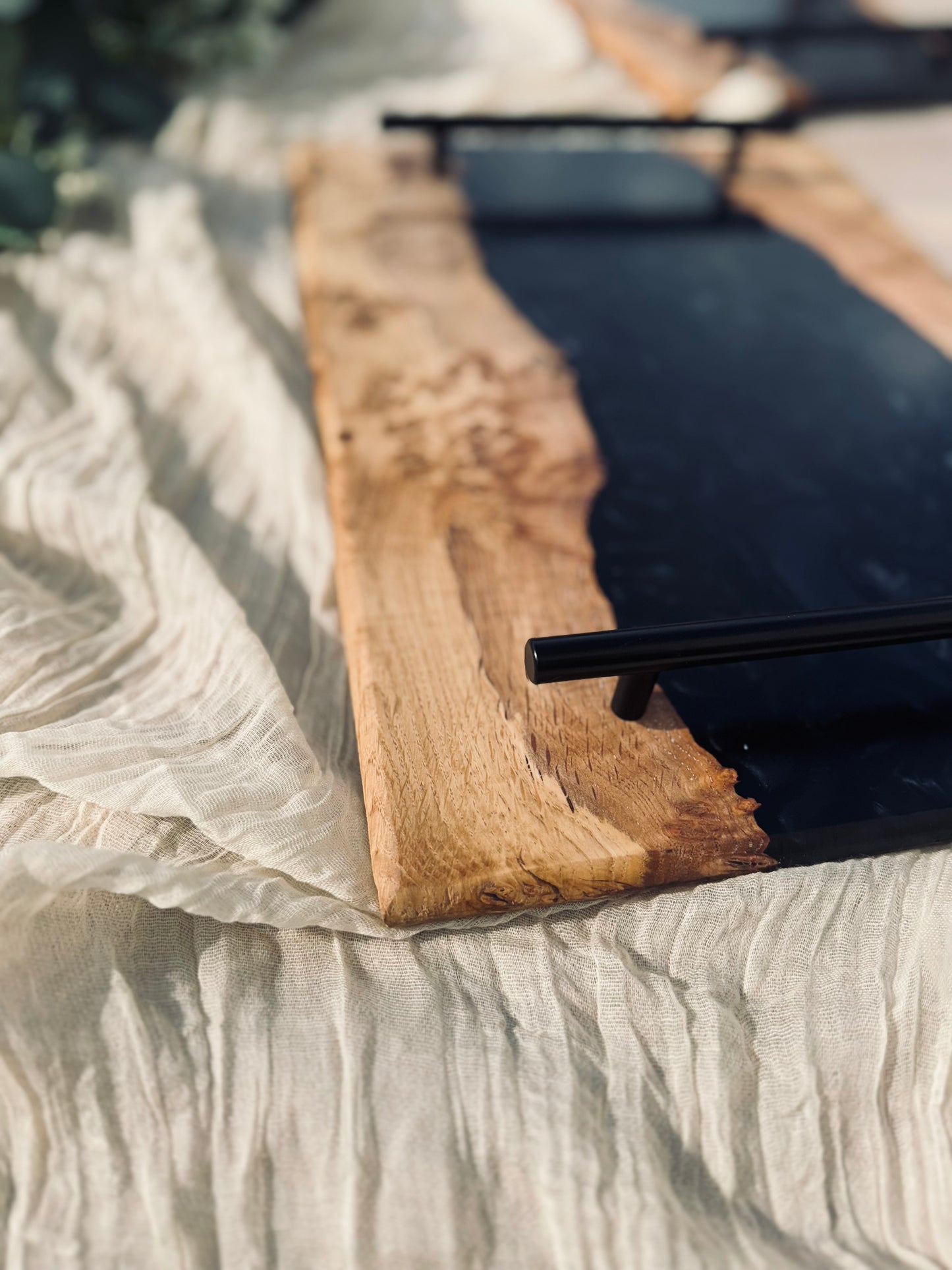 Oak burr and black onyx epoxy serving tray image of the handles on the serving tray which are a black metal