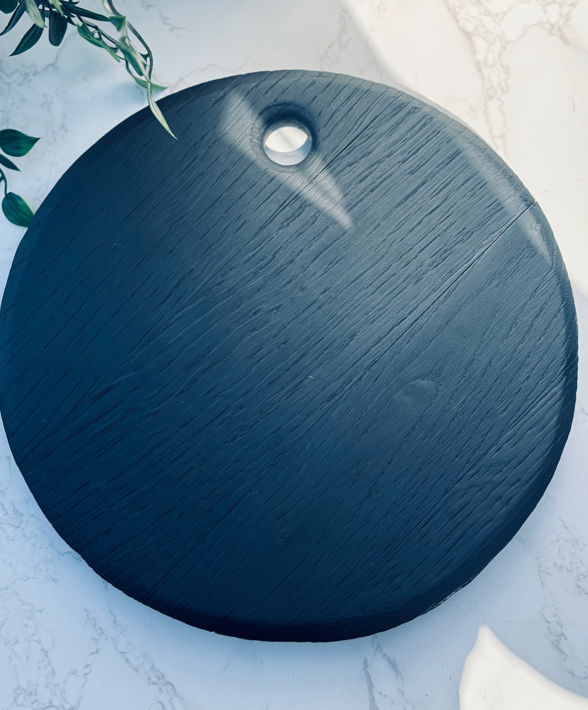 Textrured rim noir board layed flat on a marble side
